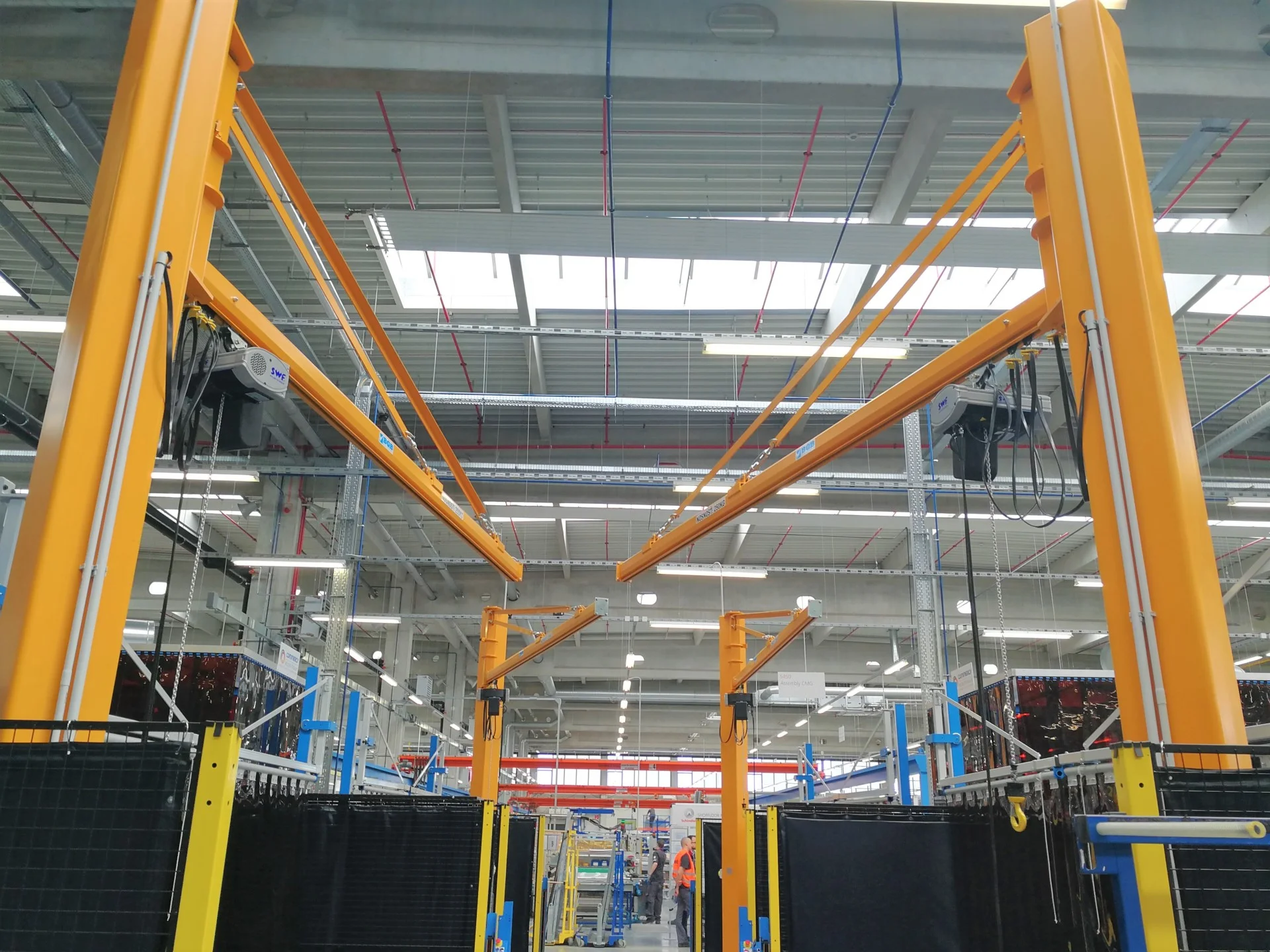 štyri stĺpové otočné žeriavy vo výrobnom hale s nosnosťou 250 kg a so závesnými ovládačmi